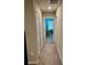 Hallway with carpeted floors, neutral walls, and doors leading to various rooms at 2040 Milkweed St, Ocoee, FL 34761