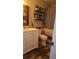 Bathroom featuring a white vanity, framed mirror, wood look floors, shelving, and neutral color palette at 205 Lexingdale Dr, Orlando, FL 32828