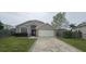 Charming single-story home boasts a lovely brick and neutral stucco facade and paver driveway at 205 Lexingdale Dr, Orlando, FL 32828