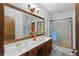 A bathroom featuring a double sink vanity, and a glass-enclosed shower with blue towels on display at 2102 Congress Ln, St Cloud, FL 34769