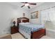 Bright bedroom with cherry wood bed frame, bedside table, and window at 2102 Congress Ln, St Cloud, FL 34769