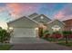 Charming single-story home with manicured landscaping, a two-car garage, and warm exterior lighting at 2102 Congress Ln, St Cloud, FL 34769