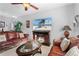 Cozy living room showcasing a decorative fireplace, leather furniture, and a ceiling fan at 2102 Congress Ln, St Cloud, FL 34769