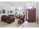 Comfortable living room featuring leather seating, a ceiling fan, and a decorative stained glass front door at 2102 Congress Ln, St Cloud, FL 34769
