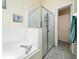 Modern bathroom with a glass-enclosed shower and a separate bathtub at 2150 Flintlock Blvd, Kissimmee, FL 34743