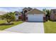 Inviting single Gathering home showcasing well-manicured lawn, 2 car garage, and mature landscaping at 2150 Flintlock Blvd, Kissimmee, FL 34743