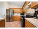 Open kitchen features wood cabinets, stainless steel appliances, tile floors, and plenty of counter space at 2150 Flintlock Blvd, Kissimmee, FL 34743