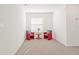 Bright bedroom featuring neutral carpeting, a window with blinds, and two red chairs with pillows at 2188 Tay Wes Dr, St Cloud, FL 34771
