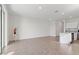 Bright, open-concept living room with neutral tile flooring, white walls, and stainless steel appliances in the kitchen area at 2188 Tay Wes Dr, St Cloud, FL 34771