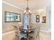 Cozy dining area with a round wood table and elegant chandelier lighting at 228 Sorrento Rd, Poinciana, FL 34759