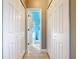 Hallway featuring white doors and a view into a bathroom with light blue walls at 228 Sorrento Rd, Poinciana, FL 34759