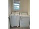 Bright laundry room with modern washer and dryer units and natural light from a window at 2755 Gentle Rain Dr, Davenport, FL 33837