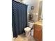 The bathroom features a shower with a stylish blue shower curtain and granite countertops at 2917 Kokomo Loop, Haines City, FL 33844