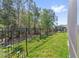 View of the backyard with black metal fence and lush greenery in the background at 3010 Camden Way, Davenport, FL 33837