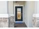 Elegant front door with decorative glass, stone accents, and a brick walkway creating a welcoming entrance at 3010 Camden Way, Davenport, FL 33837