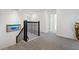 Upstairs hallway with gray carpet, black railing, and bright lighting at 3010 Camden Way, Davenport, FL 33837