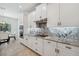 Modern kitchen featuring granite countertops, stainless appliances, and white cabinets at 3010 Camden Way, Davenport, FL 33837