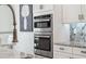 Close up on a built-in stainless oven and granite countertops in a modern kitchen at 3010 Camden Way, Davenport, FL 33837
