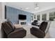 Cozy living room with a blue accent wall, fireplace, and comfortable leather seating with natural light at 3010 Camden Way, Davenport, FL 33837