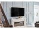 Living room detail with a fireplace, mounted tv, and a tasteful blue paneled wall design at 3010 Camden Way, Davenport, FL 33837