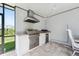 Well-equipped outdoor kitchen featuring a built-in grill, stainless steel appliances, and granite countertops at 3010 Camden Way, Davenport, FL 33837