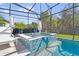 Gorgeous screened-in pool with a spa featuring decorative tile accents and lush greenery at 3010 Camden Way, Davenport, FL 33837