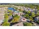 Community aerial view showcases the clubhouse, pool, parking, landscaping and multi-colored townhomes on a sunny day at 4002 San Gallo Dr # 106, Kissimmee, FL 34741