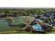 Aerial view showcasing community amenities including tennis courts, basketball court, pool, playground, and clubhouse by the lake at 4002 San Gallo Dr # 106, Kissimmee, FL 34741