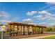 Wooden pergola with benches overlooking a pond and colorful community buildings at 4002 San Gallo Dr # 106, Kissimmee, FL 34741