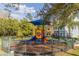 Bright, colorful playground with slides and climbing structures in a fenced-in area surrounded by trees at 4002 San Gallo Dr # 106, Kissimmee, FL 34741