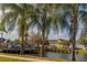 Scenic pond view with palm trees, wooden deck, and community buildings in the background at 4002 San Gallo Dr # 106, Kissimmee, FL 34741