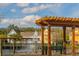 Scenic view of a pond with a fountain, wooden pergola, and colorful buildings in the community at 4002 San Gallo Dr # 106, Kissimmee, FL 34741
