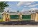 Community tennis courts viewed through a pergola entryway with manicured landscaping at 4002 San Gallo Dr # 106, Kissimmee, FL 34741