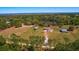 Aerial view of a home on a spacious lot with mature trees and a pond at 41636 Outlaw Ln, Weirsdale, FL 32195