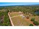 Aerial view of a home with outbuildings on a large, wooded lot at 41636 Outlaw Ln, Weirsdale, FL 32195