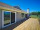Rear of home showcasing large sliding glass doors and a spacious wooden deck at 41636 Outlaw Ln, Weirsdale, FL 32195