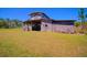 Rustic wooden barn with a covered area, surrounded by a grassy field at 41636 Outlaw Ln, Weirsdale, FL 32195
