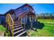 Barn featuring a raised structure, wooden staircase, and ample space for storage with green surroundings at 41636 Outlaw Ln, Weirsdale, FL 32195
