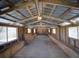 Barn interior featuring an open layout, wooden beams, natural light, and ample space for storage at 41636 Outlaw Ln, Weirsdale, FL 32195