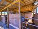 Well-built barn featuring multiple stalls, wooden structure, and equipment storage for equestrian or farm use at 41636 Outlaw Ln, Weirsdale, FL 32195