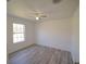 A clean bedroom features gray wood-look flooring and a modern ceiling fan and light at 41636 Outlaw Ln, Weirsdale, FL 32195