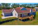 Backyard view of a two-story home highlighting the spacious deck, well-maintained lawn, and landscaping at 41636 Outlaw Ln, Weirsdale, FL 32195