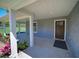 Welcoming front porch featuring stylish pillars, colorful landscaping, and an inviting entrance at 41636 Outlaw Ln, Weirsdale, FL 32195