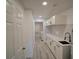 Beautiful hallway with new gray floors, white walls, and updated cabinets and countertops at 41636 Outlaw Ln, Weirsdale, FL 32195