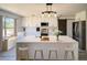 Bright kitchen with a large island, modern lighting, white cabinetry, and stainless steel appliances at 41636 Outlaw Ln, Weirsdale, FL 32195