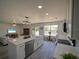 Contemporary open-concept kitchen with stainless steel appliances and a dining area overlooking the living room at 41636 Outlaw Ln, Weirsdale, FL 32195