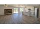 Spacious living room with a stone fireplace and a modern kitchen with stainless steel appliances at 41636 Outlaw Ln, Weirsdale, FL 32195