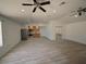 Expansive living room featuring light wood flooring and kitchen in background at 41636 Outlaw Ln, Weirsdale, FL 32195