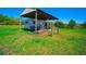 RV carport offering ample space, sturdy wooden supports, and shaded parking for recreational vehicles in grassy yard at 41636 Outlaw Ln, Weirsdale, FL 32195