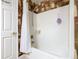 Close-up of a bathtub with shower features and a white shower curtain, set against a patterned wallpaper backdrop at 439 Madera Pass, Poinciana, FL 34759